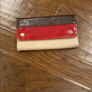 Tan, black, and red wallet